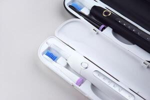 Modern electric ultrasonic toothbrush with rechargeable battery on the white surface photo