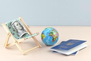 A Ukraine passport and chaise lounge with dollars and globe on a light background. photo