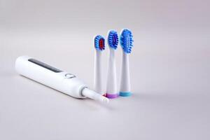 One white modern electric ultrasonic toothbrush on the gray surface photo