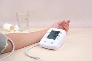 The Digital blood pressure tonometer and pack of pills photo