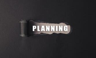 Planning is the word that is written on the black background photo