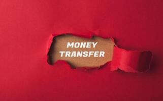 Red background with a hole in it and the words money transfer written in white photo
