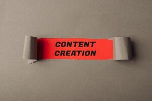 Words Content Creation on red view through torn paper photo