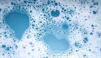 top view of blue foamy soap water with delicate bubbles and clear patches, macro hygiene and cleaning abstract texture photo
