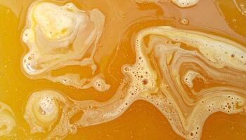abstract close-up of melted golden wax pool texture with natural swirls and foamy surface, top view fluid wax movement for background design photo
