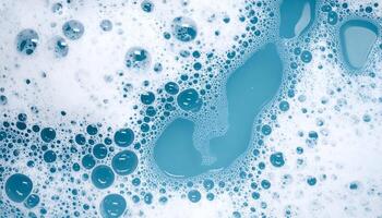 macro view of blue soap water surface with frothy foam bubbles, top down abstract hygiene and cleaning texture background photo