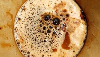 top view of stained coffee filter with bubbly crema and dark roast residue, textured caffeine foam background for coffee design and beverage art photo