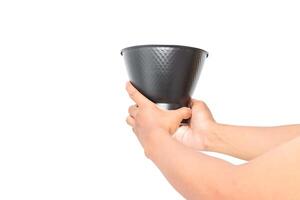 Hands holding a black metallic bucket, isolated on white background, studio shot photo
