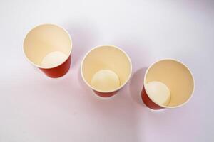 Three Empty Red and Cream Paper Cups on White Background photo