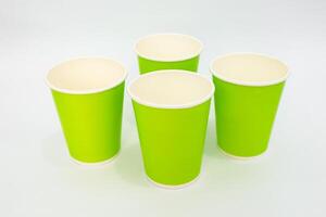 A vibrant quartet of green paper cups arranged on a clean, white background with soft lighting, showcasing a sense of eco-friendliness photo