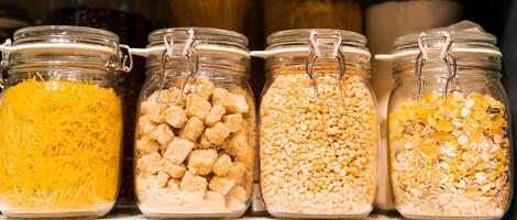 banner stand in a row of glass jars on a shelf with pasta, the concept of organizing a kitchen space photo
