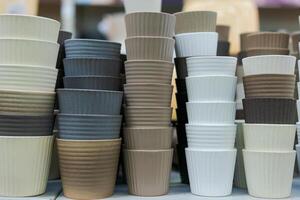stacks of pots for flowers or for gardening on a shelf in a store of different colors photo