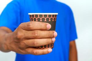 A Person Holding a Disposable Coffee Cup Against a White Background in Studio Lighting photo