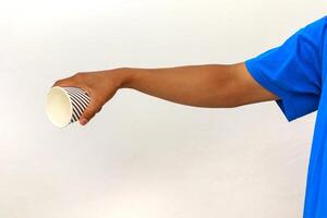 Hand holding a striped paper cup against a white background, wearing a blue shirt, isolated object for beverage or food promotion photo