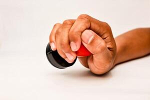 A hand holding a black and red rubber stamp ready to apply to a document or form for approval photo