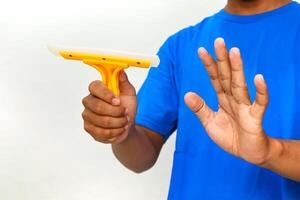 A man holding a yellow window squeegee and his hand up as if to stop something, cleaning equipment photo