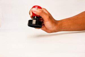 Close up of a person holding a red and black rubber stamp in their hand ready to make a mark photo