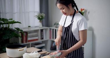 Handheld high angle view shot, A young woman is mixing minced pork with various seasonings in a bowl. video