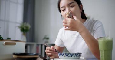 Handheld low angle view shot, Asian woman is happy to have delicious noodles for lunch on the table at home. Enjoying hot pot noodles. video