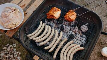 Professional chef grilling sausages and chicken over hot charcoal, grilling scenes rich with smoke and flavor, grilling captured in slow motion to enhance summer cookout atmosphere. Barbecue concept video