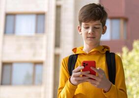 Teenage boy with a smartphone smiles while looking at the screen. Highlights endless opportunities for learning, entertainment, and communication through digital devices. photo