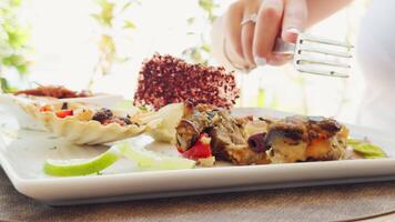 Woman Hand Cuts Fish Appetizer Food From A Plate In Summer From A Restaurant video