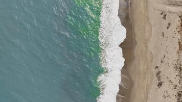 Overhead Of A Sea With Waves Crashing On The Sandy Shore video