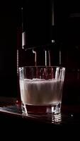 Making coffee into glass cup, espresso coming out from an automatic coffee maker machine. Cappuccino, latte for breakfast in modern dark kitchen. Highlighting process of making aromatic video
