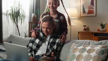 Caucasian family problem multitasking mother stressed daughter noisy bad behavior woman freelancer working laptop with two mobile phones notebook distant work at home little child kid girl distracting video