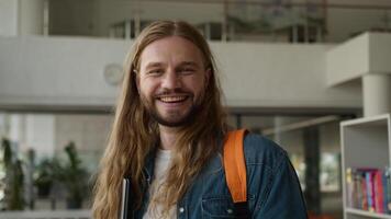 Portrait Caucasian student guy man male positive carefree in university college academy hallway corridor holding laptop smiling happy looking at camera studying learning success satisfied education video
