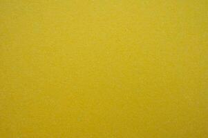 Full frame shot of recycled yellow paper sheet texture and background. Colored paper or construction paper, is a type of paper that comes in a wide range of colors. photo