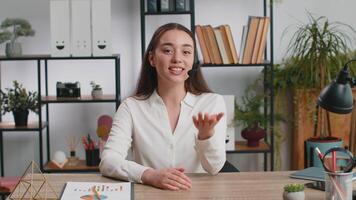 POV portrait of young business woman wearing headset, freelance worker call center or support service operator helpline, having pleasant talk with client or colleague communication support at office video
