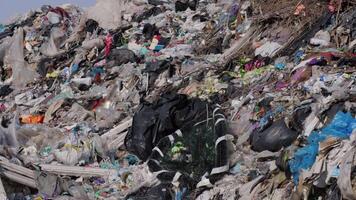 A large landfill overflowing with various types of waste, including plastic and debris, raises concerns about pollution and environmental management video