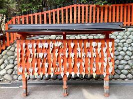 Osaka city, JP 2024 - Wooden Plate of ema in the Japanese fox face of Fushimi Inari Shrine. Ema are small wooden plaques to write prayers, often hanging at shrine, temples in Japan. photo