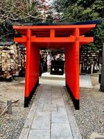 Kyoto city, JP 2024 - Closeup small Torii gate with part way in the in the Tofuku-ji temple area and see Ema wooden plate behind. photo