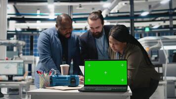 Professional engineering team reviewing solar panels next to chroma key, showcasing unity in green technology and eco friendly alternative energy. Manufacturing plant industry. Camera B. video