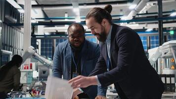 Factory inspectors and supervisors engaging in briefing over production metrics, supporting industrial innovation and sustainable process improvement. Solar power manufacturing. Camera B. video