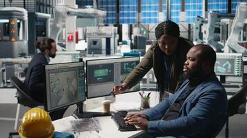 African american factory experts engaging in manufacturing process analysis, reviewing industrial operations for the production line. Solar power high tech development. Camera B. video