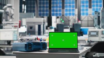 Futuristic solar panel production facility with copy space on empty desk, protective gear and laptop display shows photovoltaic performance. Manufacturing progress and automation. video