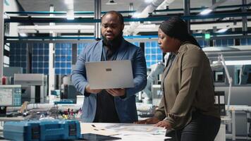 Black engineering professionals and directors review operational workflows in a solar manufacturing facility. Integrating teamwork in renewable energy production and development. Camera B. video