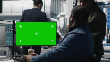 Solar power diverse team reviewing insight on pc next to green screen, finding errors during manufacturing process and helping optimize clean energy operations. Photovoltaics. Camera A. video