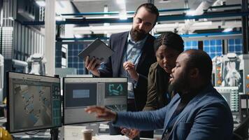 Group of professional consultants reviewing data and checklists in a high tech solar panel plant, ensuring manufacturing process meets sustainable energy and innovation standards. Camera B. video