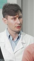 Experienced doctor attentively discussing spinal x-ray with female patient video
