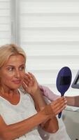 Radiant woman admires her rejuvenated skin with her cosmetologist video