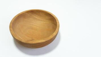 Close-up studio shot of an empty wooden bowl on a white surface displaying natural wood grain and simple craftsmanship with minimalist design photo