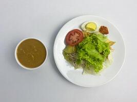 Gado-gado, Indonesian Salad with Peanut Sauce on White Background, overhead shot photo