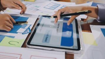A group of people working on a tablet with paper and pens video