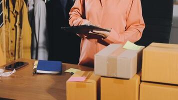 A woman is standing in front of boxes and a tablet video