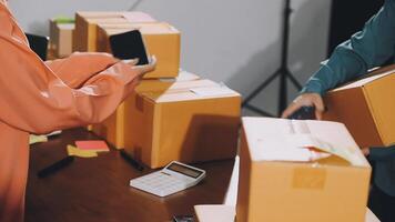 A man and woman are standing around a table with boxes video