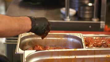 Chef preparing meat skewers in a busy kitchen, video